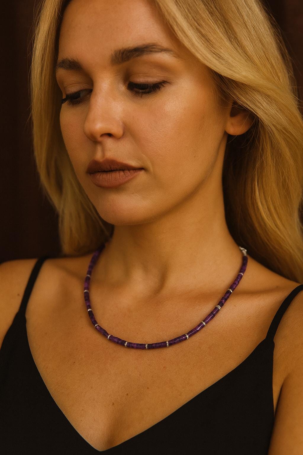 Amethyst bead necklace worn around the neck.