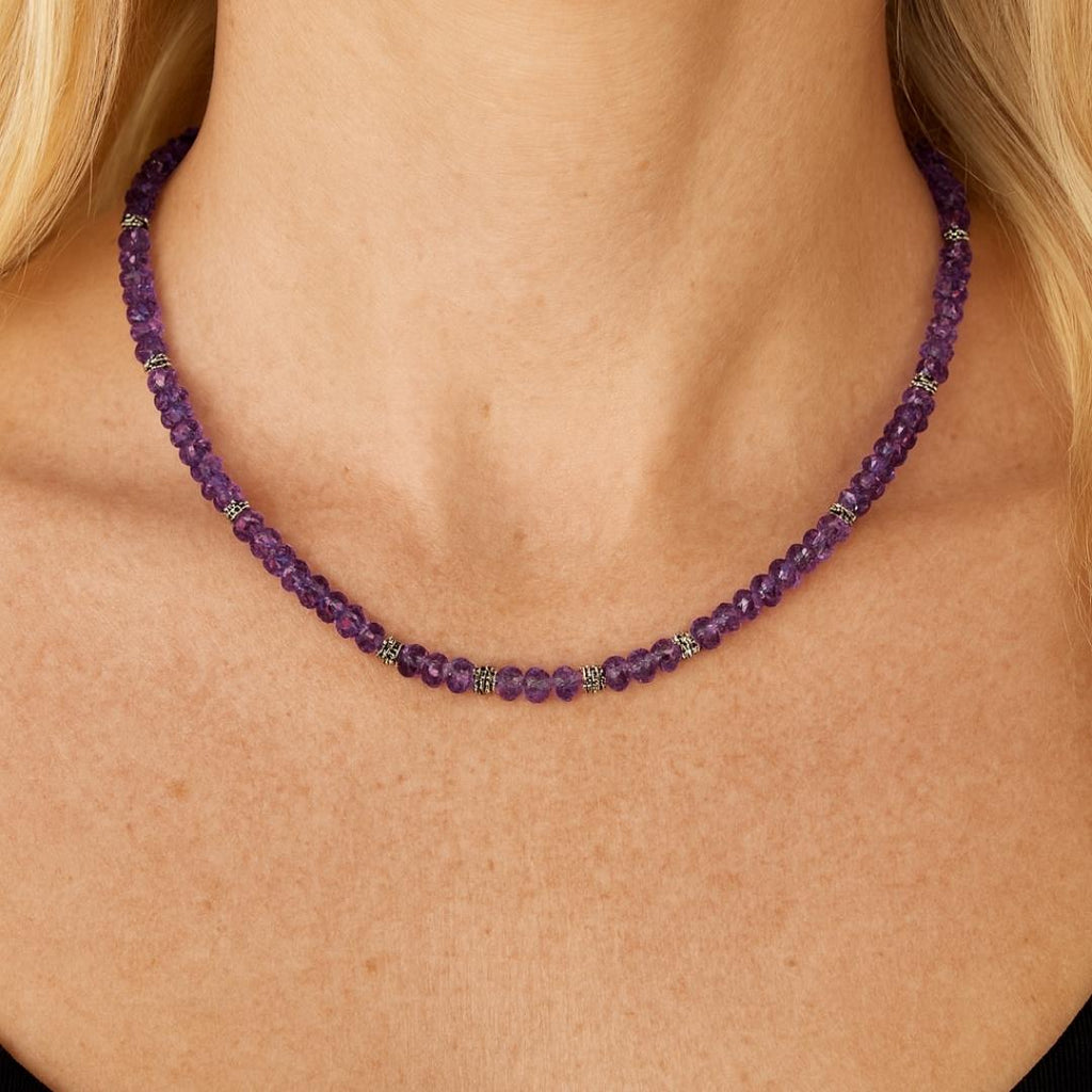 Amethyst bead necklace worn around the neck.